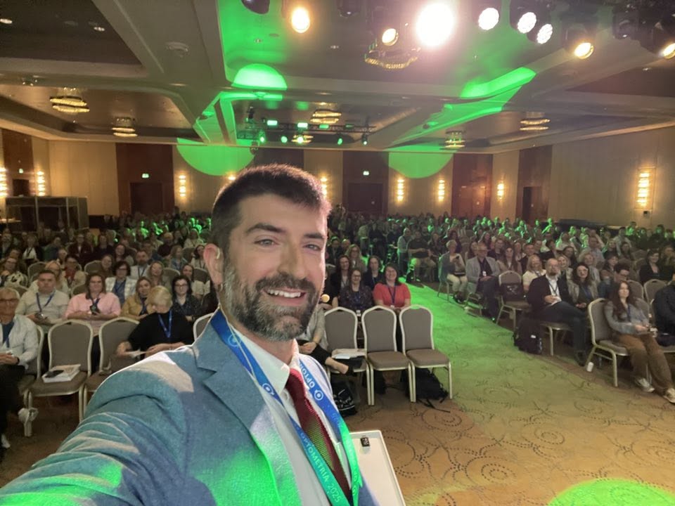 Dr. Justin Chelette speaking to a packed auditorium at an optometry conference in Kraków, Poland